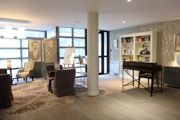 Relax in a spacious lounge area with a piano, armchairs, and a sofa.