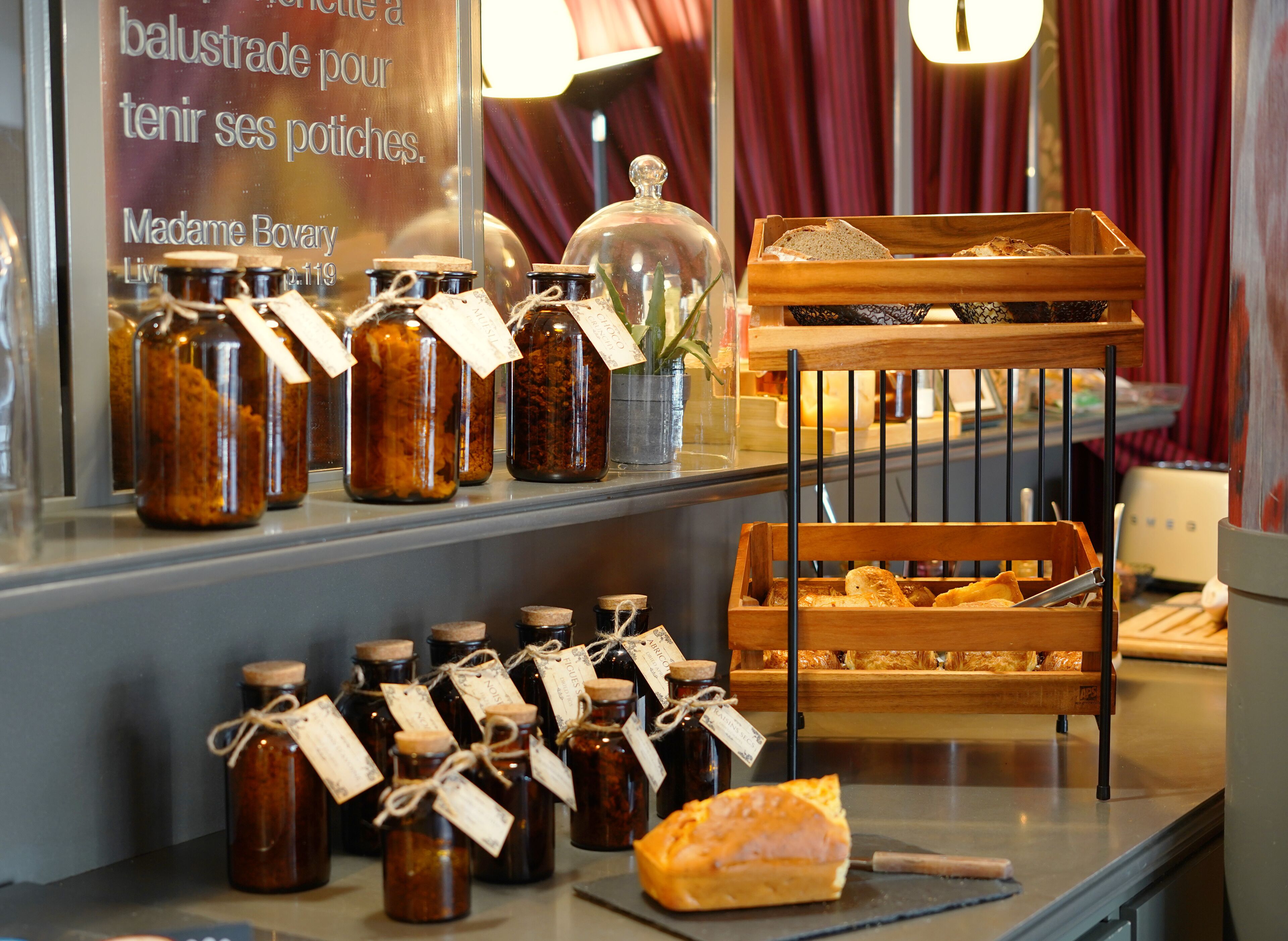 A display of jars with labels, a wooden bread basket, and a sign in a store window.