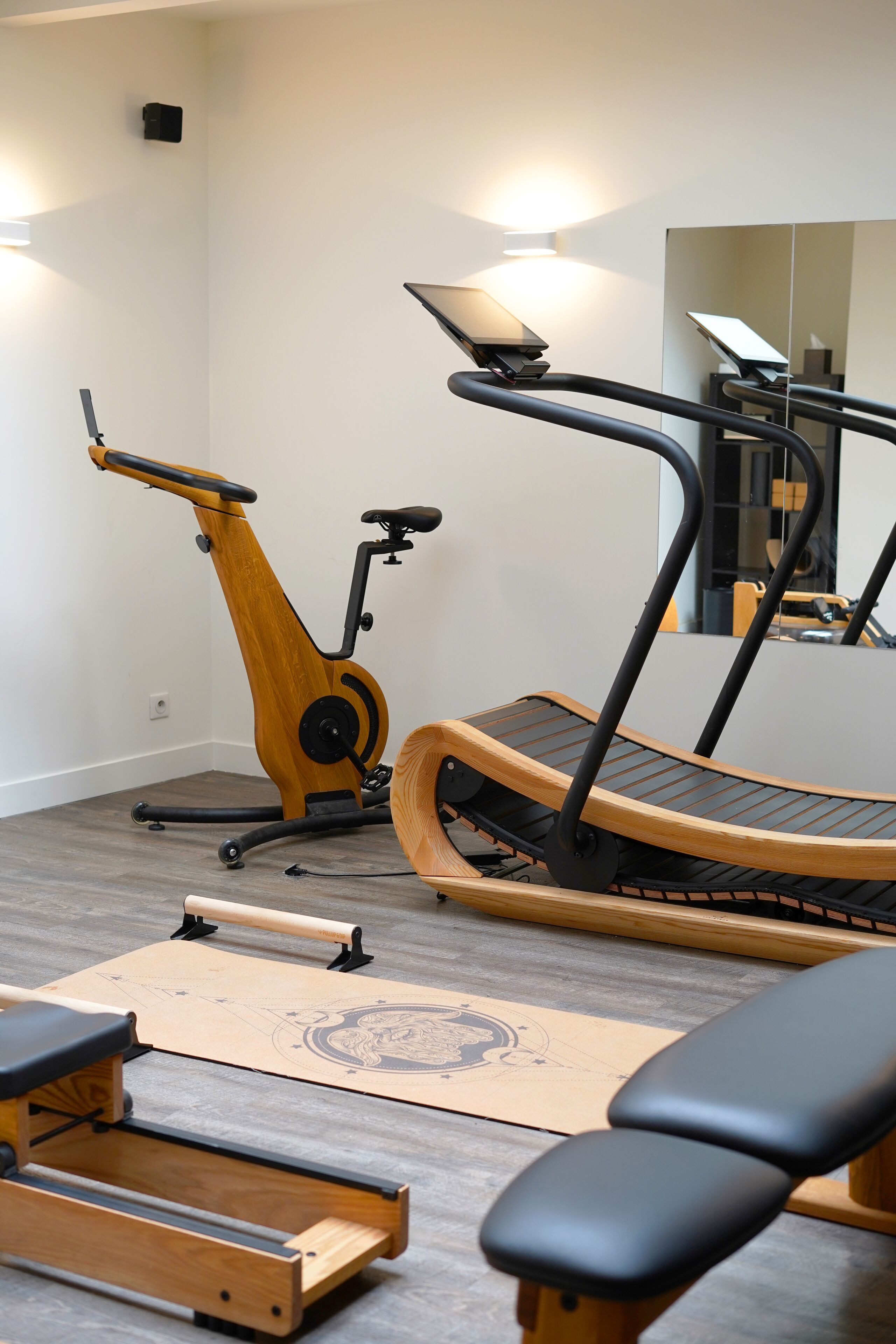 Et hjemmegymnasium med træningsudstyr, herunder en motionscykel, løbebånd og vægte.