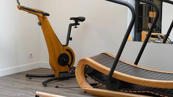 A home gym with exercise equipment including a stationary bike, treadmill, and weights.