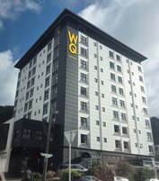 A modern hotel building with a prominent 'WQ HOTEL' sign on the facade.