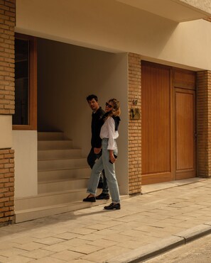 A man and a woman walking towards a building entrance with a staircase. - 9Hotel Chelton (Brussels)