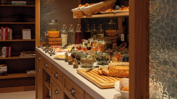 A buffet setup with various food items, condiments, and beverages. - 9Hotel Chelton (Brussels)