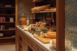 En buffet med forskellige retter, tilbehør og drikkevarer.