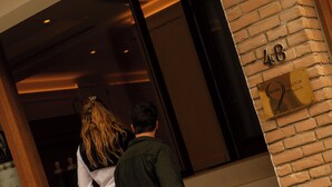 A man and a woman exiting a building with a sign indicating room number 48. - 9Hotel Chelton (Brussels)