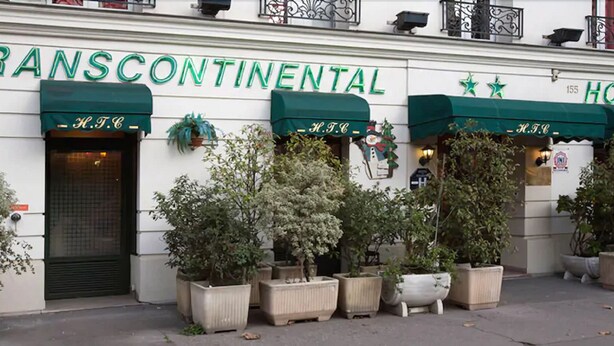 A building with the sign "Transcontinental Hotel" and green awnings. There are potted plants in front of the entrance. - Hotel Transcontinental (Paris)