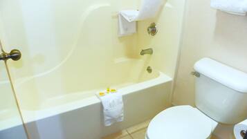 A bathroom with a bathtub, toilet, and a towel rack.