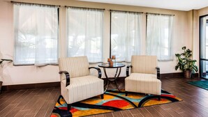 Una habitación con dos sillones tapizados, una mesita redonda y una alfombra colorida.