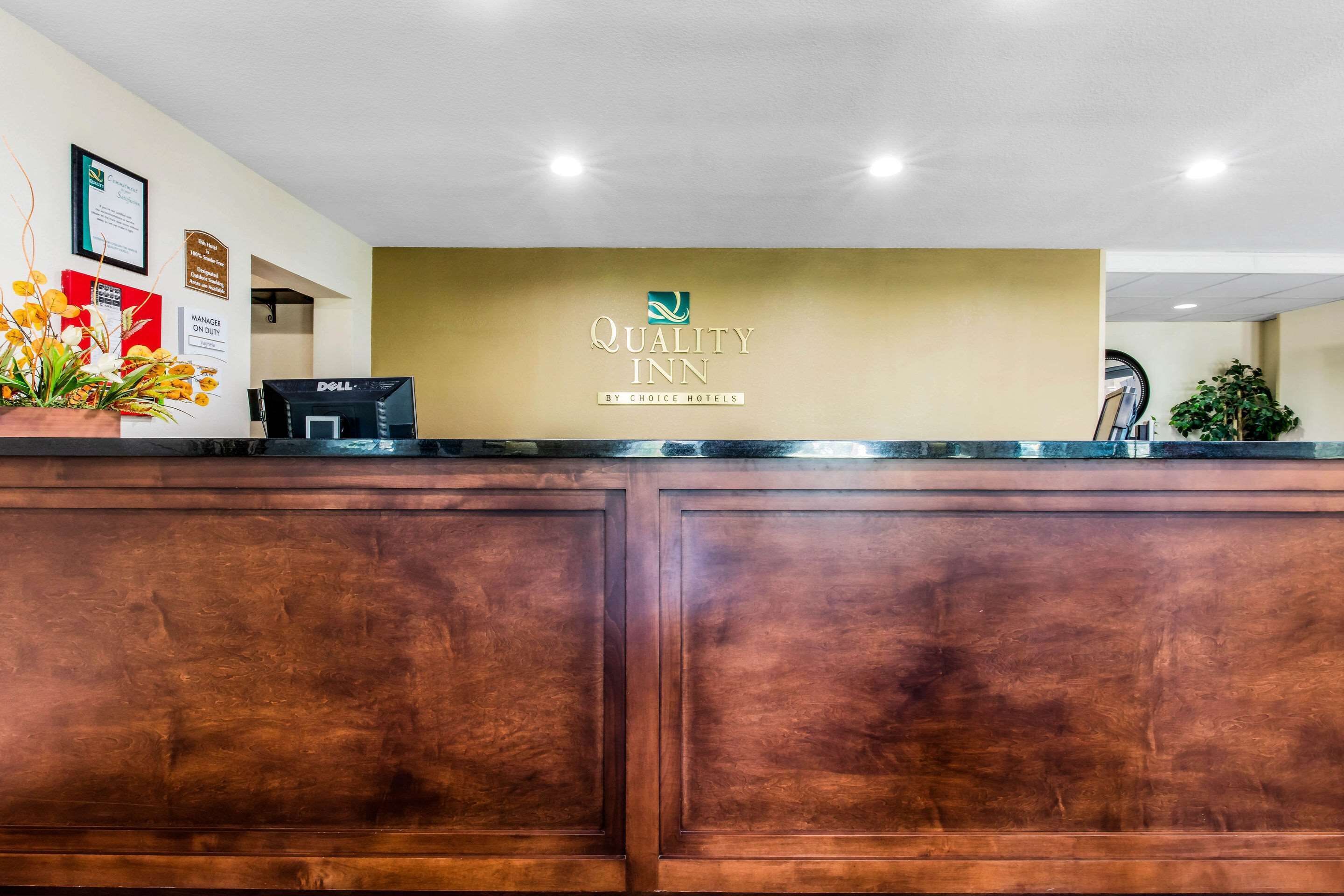 A reception desk with a sign reading "Quality Inn by Choice Hotels."