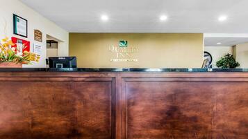 A reception desk with a sign reading "Quality Inn by Choice Hotels."