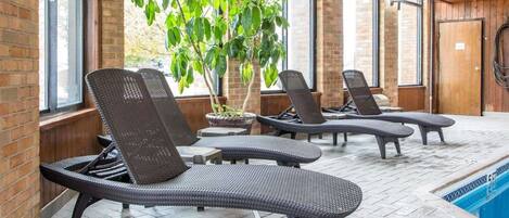 A poolside area with lounge chairs and potted plants.