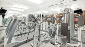 Ett gym med olika typer av träningsutrustning, inklusive löpband och styrketräningsmaskiner.