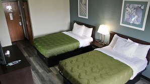 A hotel room with two beds, a desk, and a nightstand with a lamp. - Blisspoint Inn Columbia City (Columbia City)