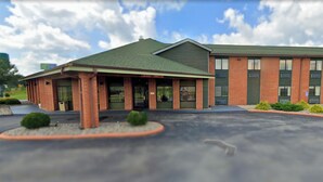 A two-story building with a green roof and brick facade. - Blisspoint Inn Columbia City (Columbia City)