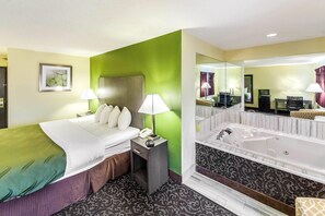 A hotel room with a bed, bedside table, lamp, and a large mirror reflecting the room.