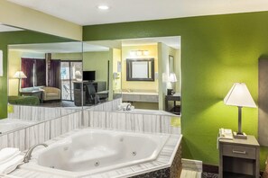 Un baño de hotel con un espejo grande, una bañera, un lavamanos y un tocador.