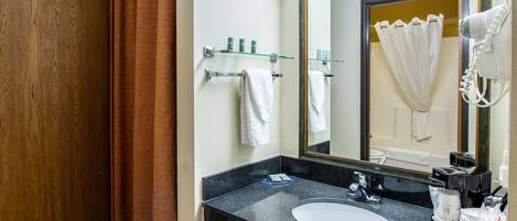 Une salle de bain avec un lavabo en granit noir, un miroir et une serviette blanche accrochée au mur.