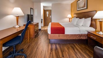 Una camera d'albergo con un letto, una scrivania, una sedia e due lampade.