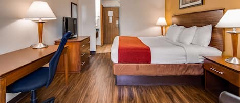 Ein Hotelzimmer mit Bett, Schreibtisch, Stuhl und zwei Lampen.