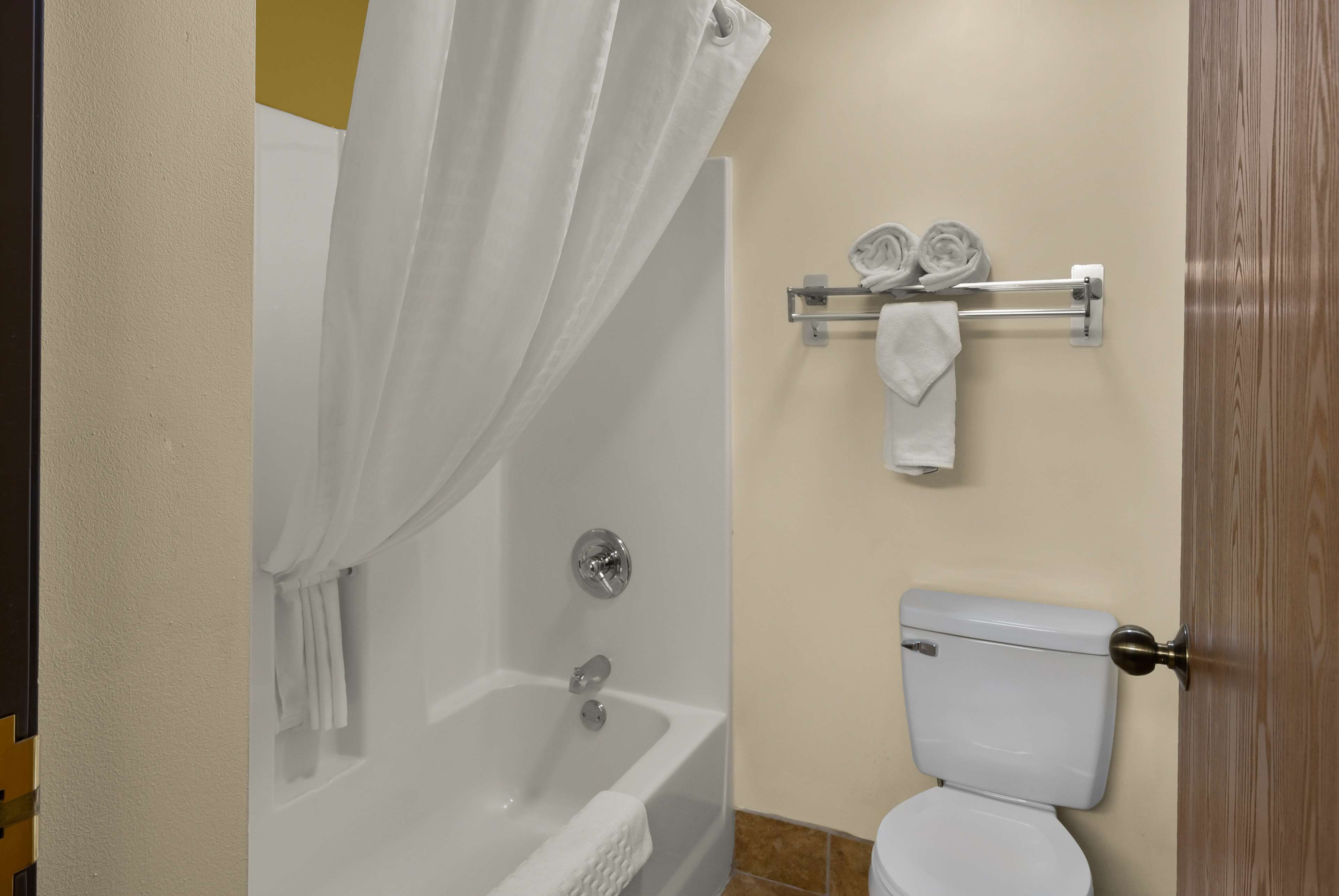 A bathroom with a bathtub, toilet, and towel rack.
