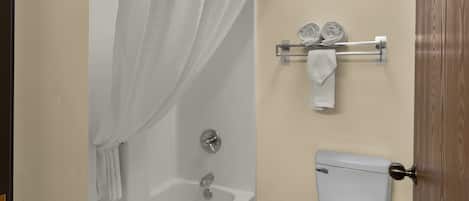 Ein Badezimmer mit Badewanne, Toilette und Handtuchhalter.