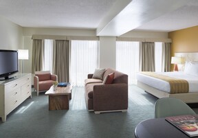 Ein Hotelzimmer mit Bett, Sofa, Schreibtisch und Fernseher.