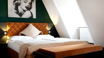 A neatly made bed with a quilted headboard, a bedside table, and a pillow.