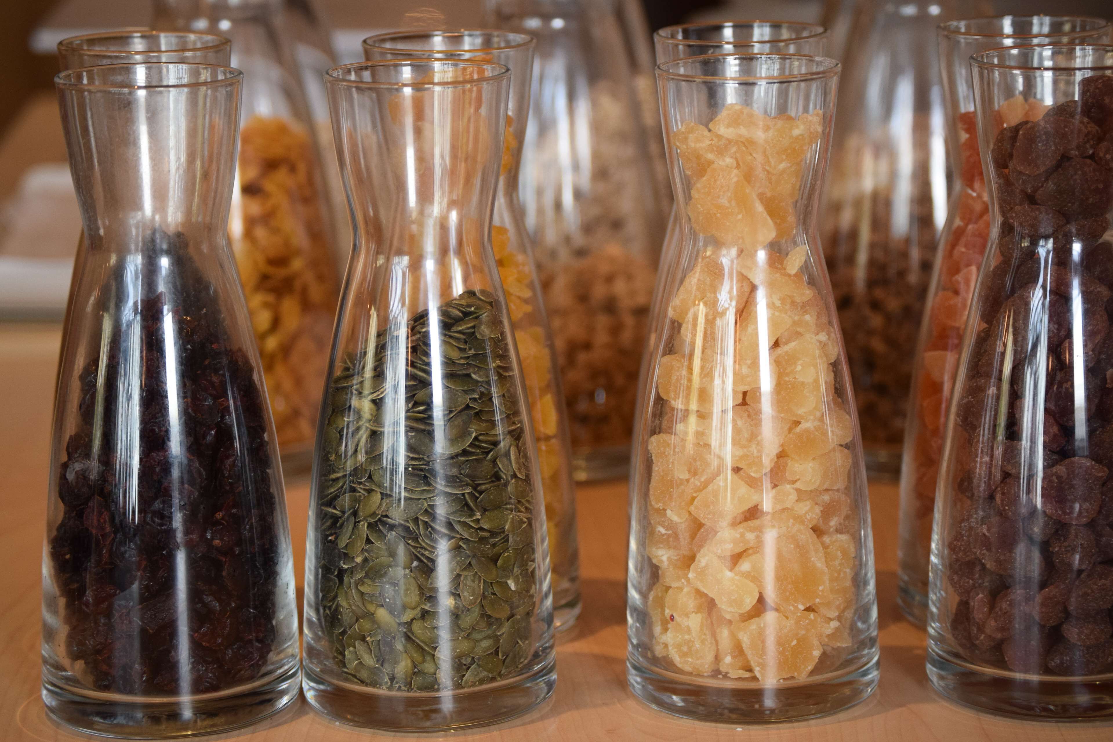 En samling glasvaser som innehåller olika sorters torkade örter och kryddor.