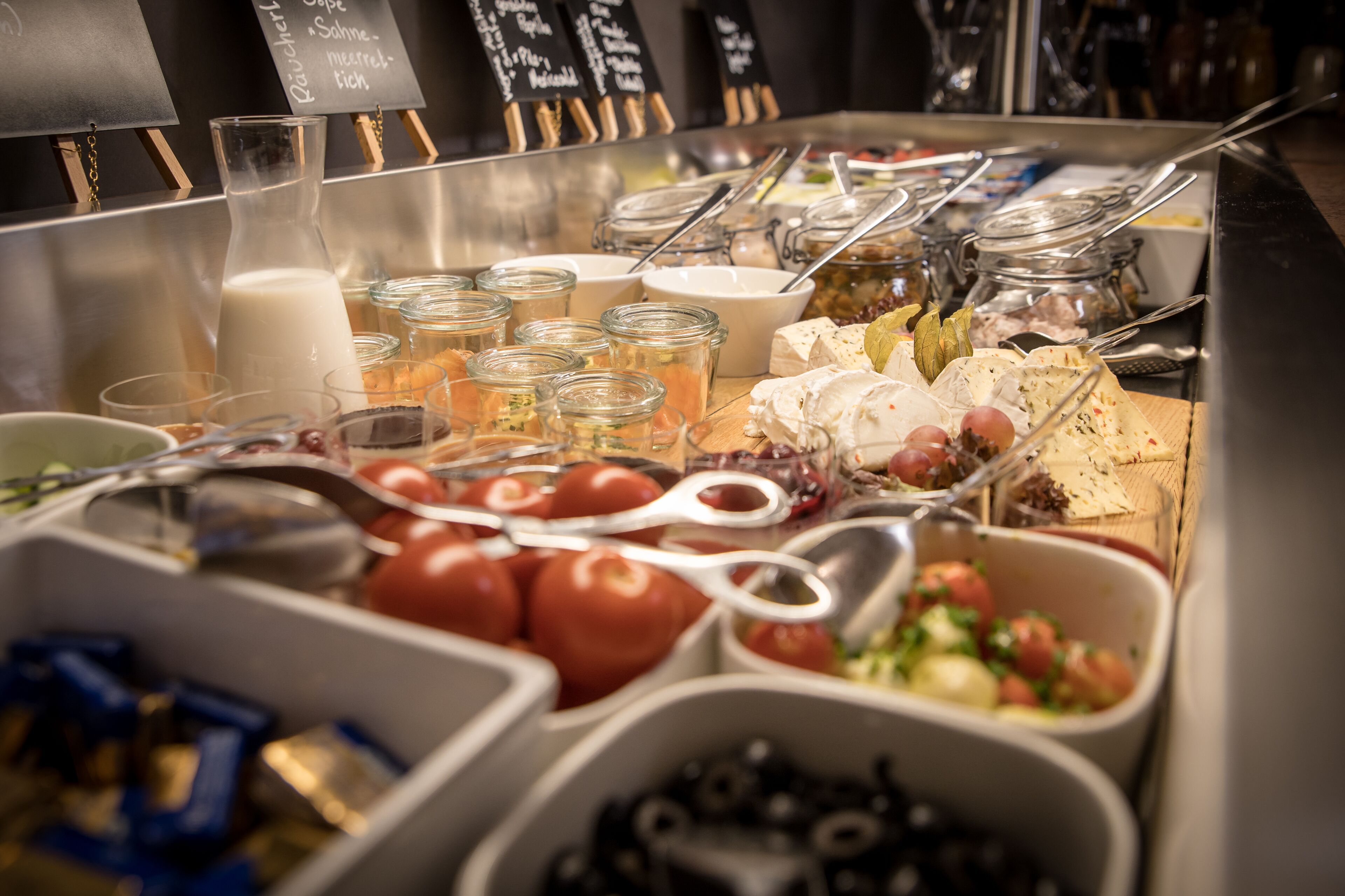 A buffet with various food items and utensils.