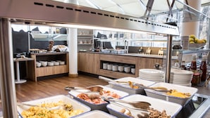 Un área de bufé con diversas opciones de comida, como huevos, carnes y ensaladas.