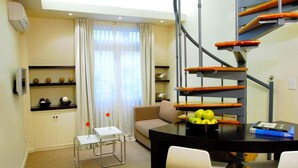 A modern living room with a staircase, a dining area, and a sofa. - Ulises Recoleta Suites (Buenos Aires)