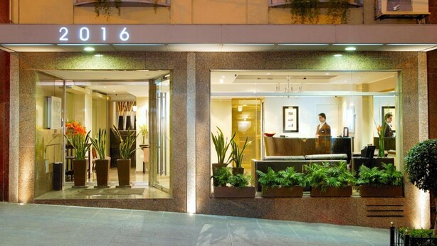 A hotel entrance with a reception desk, potted plants, and a year sign indicating 2016. - Ulises Recoleta Suites (Buenos Aires)