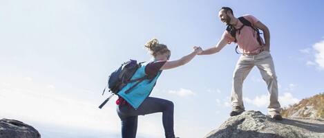 Two people hiking on a mountain with a clear sky.