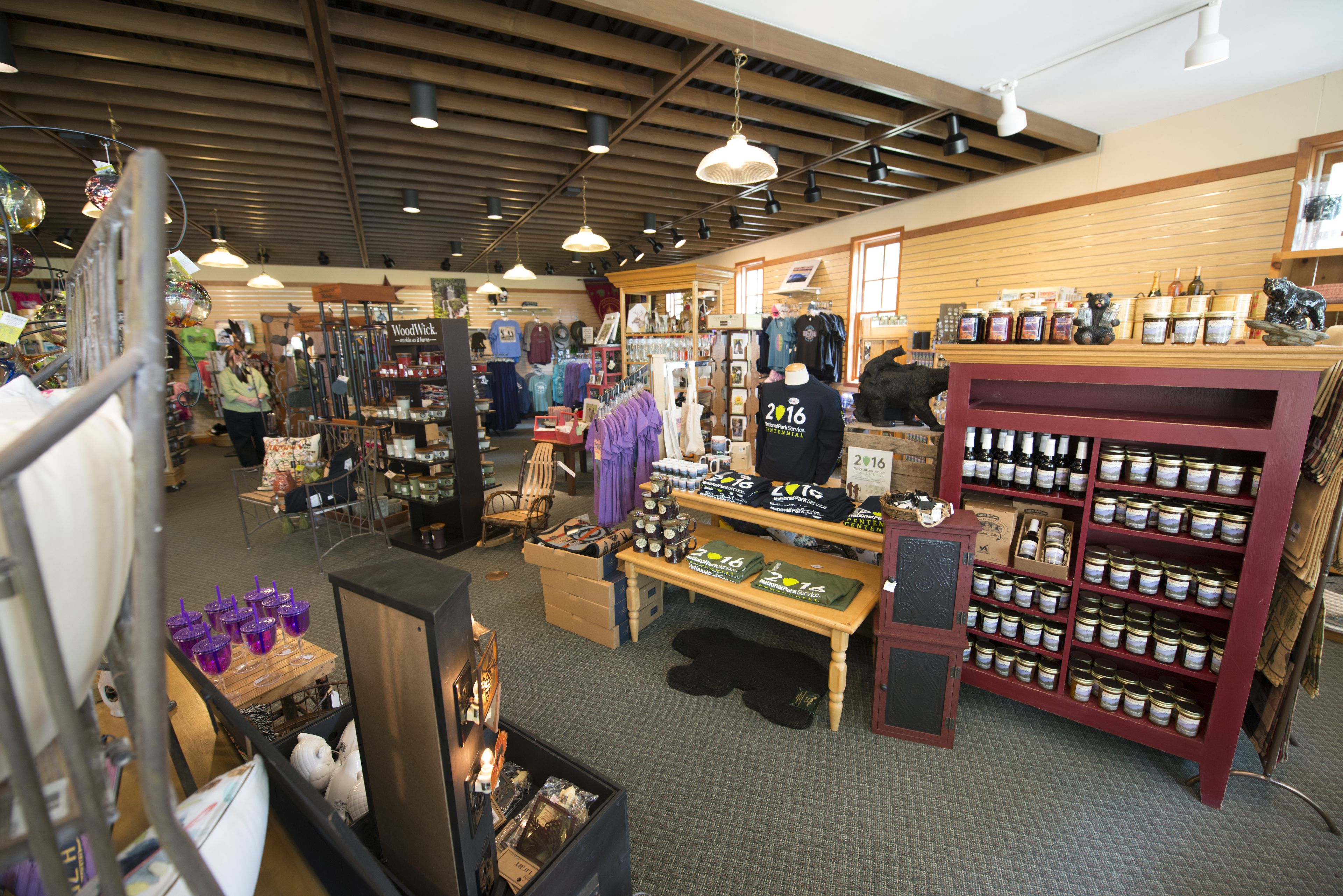 A store with various items on shelves and tables, including clothing and canned goods.