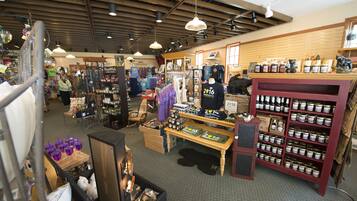 A store with various items on shelves and tables, including clothing and canned goods.