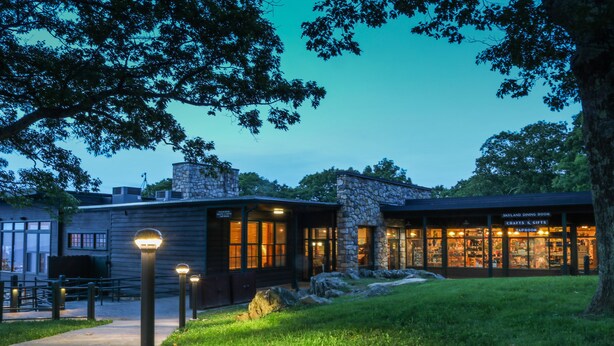 A building with a stone facade, a dining area, and a craft shop. - Skyland (Luray)
