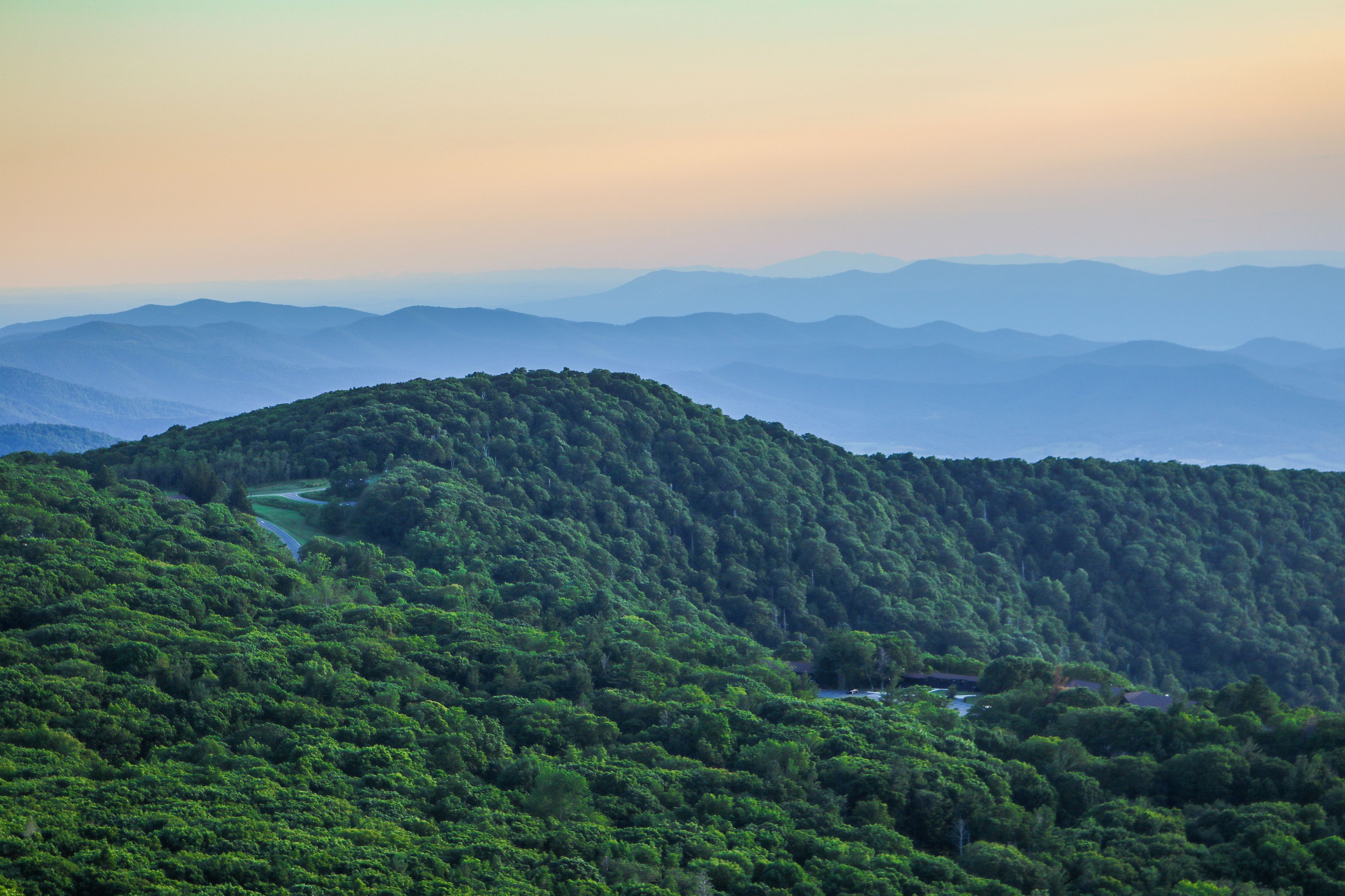 A mountainous landscape with dense forestation and a winding river.