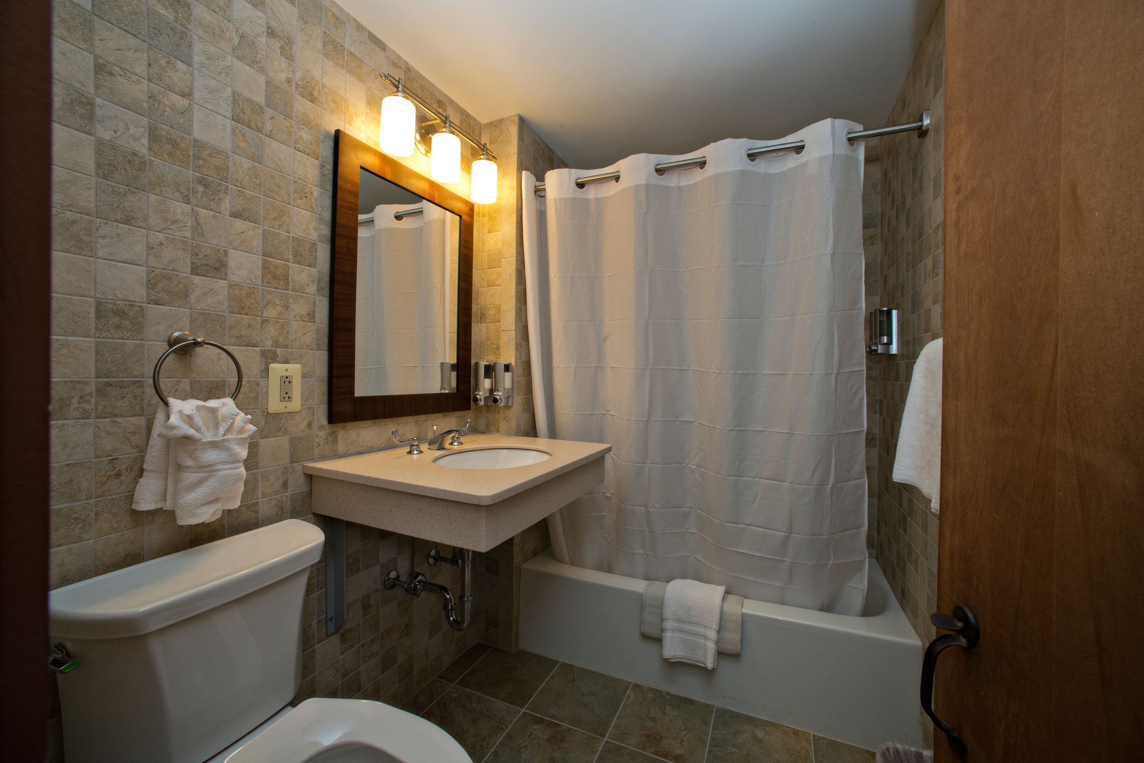 A bathroom with a toilet, sink, and bathtub.