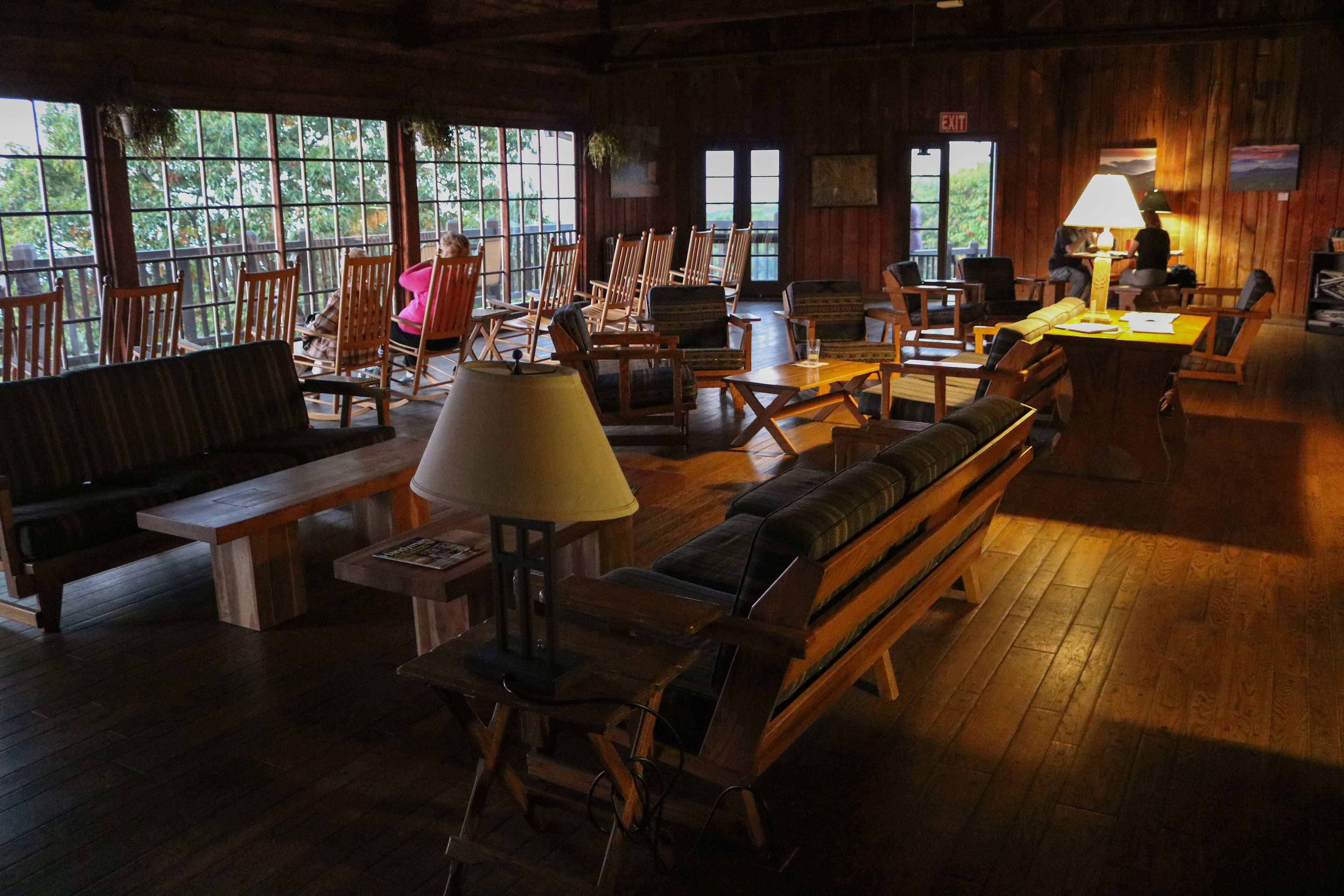 A cozy, rustic interior with wooden furniture, large windows, and a warm ambiance.