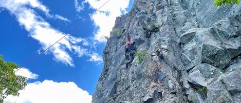 A person rappelling down a rocky cliff.