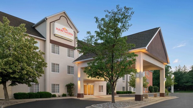 A hotel with a modern design, featuring a prominent sign for 'Hawthorn Suites by Wyndham'.