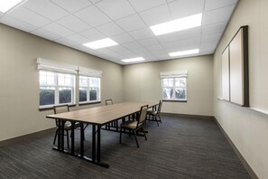 A conference room with a long table, chairs, windows, and a carpeted floor. - Homewood Suites by Hilton Newark-Fremont (Newark)