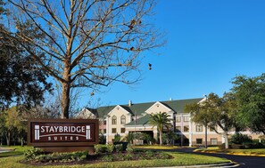 Señal de Staybridge Suites que muestra claramente la arquitectura y el paisajismo del edificio.
