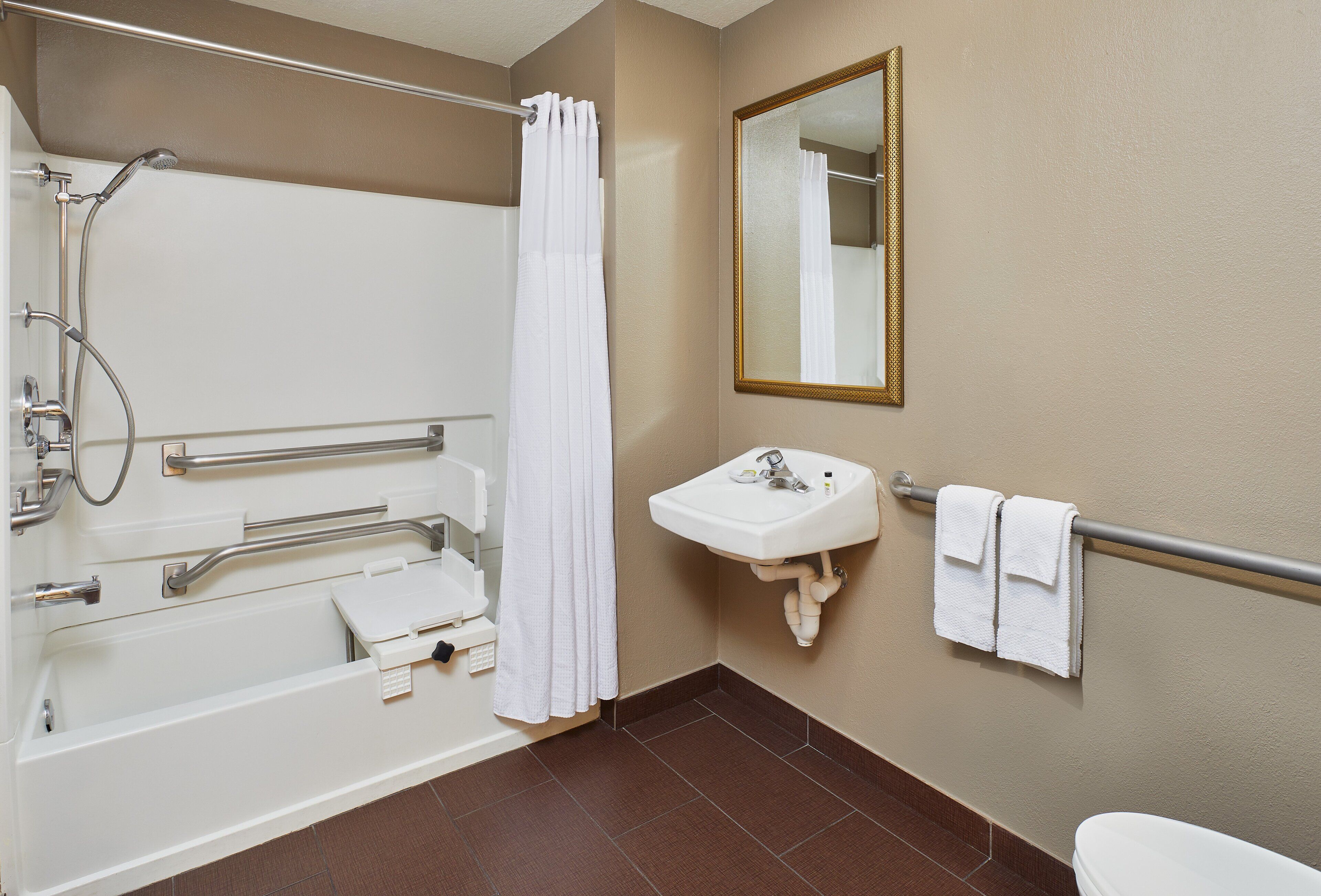 Een badkamer met een bad, douche, wastafel en toilet.