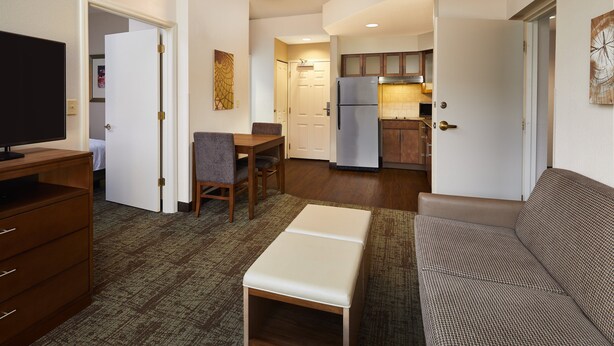 A compact living space with a kitchenette, a dining area, and a seating area. - Staybridge Suites Orlando Airport South by IHG (Orlando)