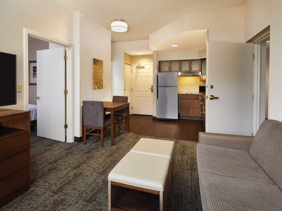 Un espacio habitable compacto con kitchenette, comedor y zona de estar.