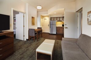 Un espacio habitable compacto con kitchenette, comedor y zona de estar.