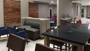 Un espace intérieur moderne avec une table de conférence noire, des sièges bleus et gris et des éléments décoratifs en bois.