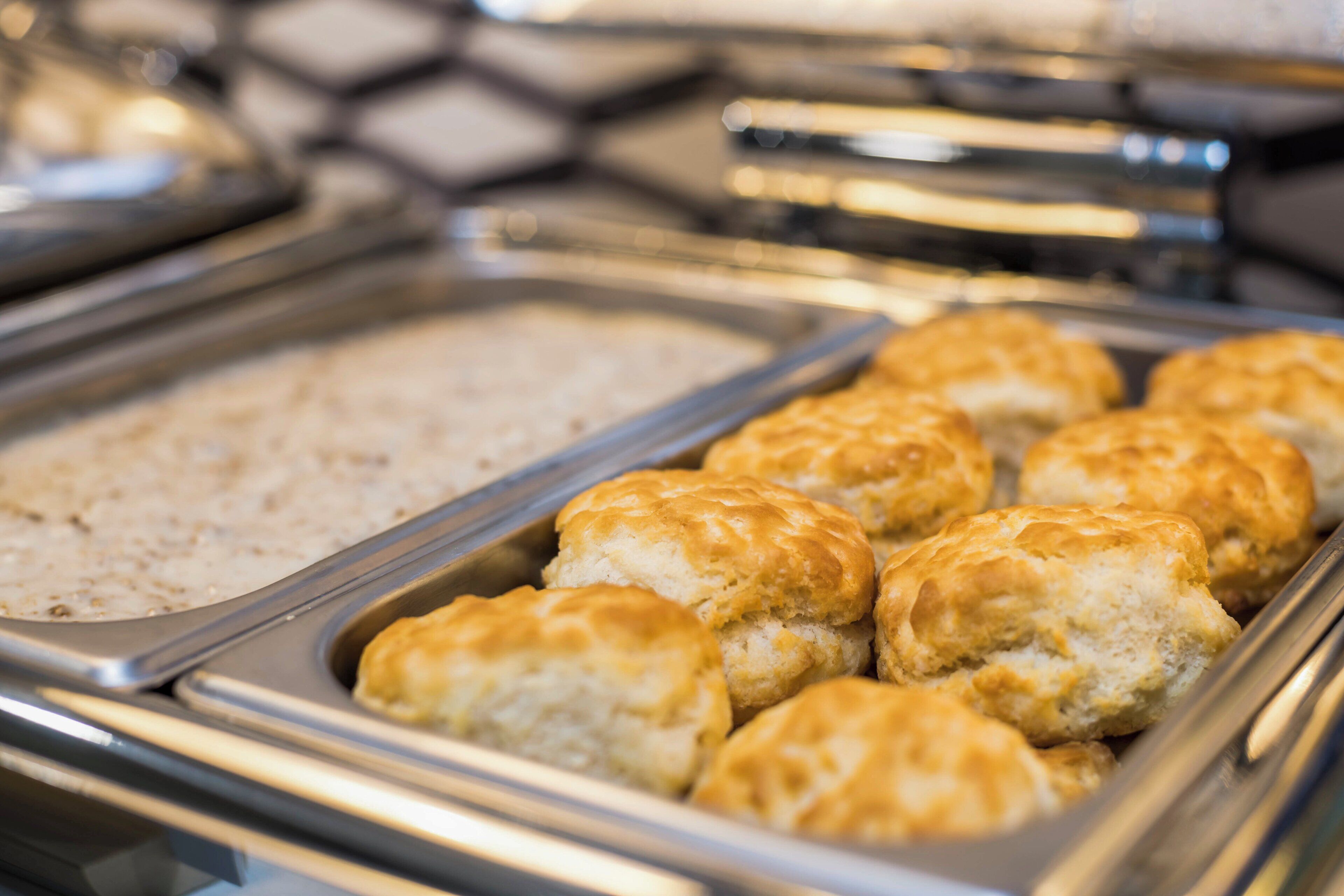 A buffet with various food items including biscuits and a dish that appears to be oatmeal.