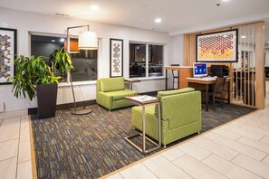 A hotel lobby with seating, a reception desk, a computer, and a large window. - Holiday Inn Express Chicago NW - Vernon Hills by IHG (Vernon Hills)